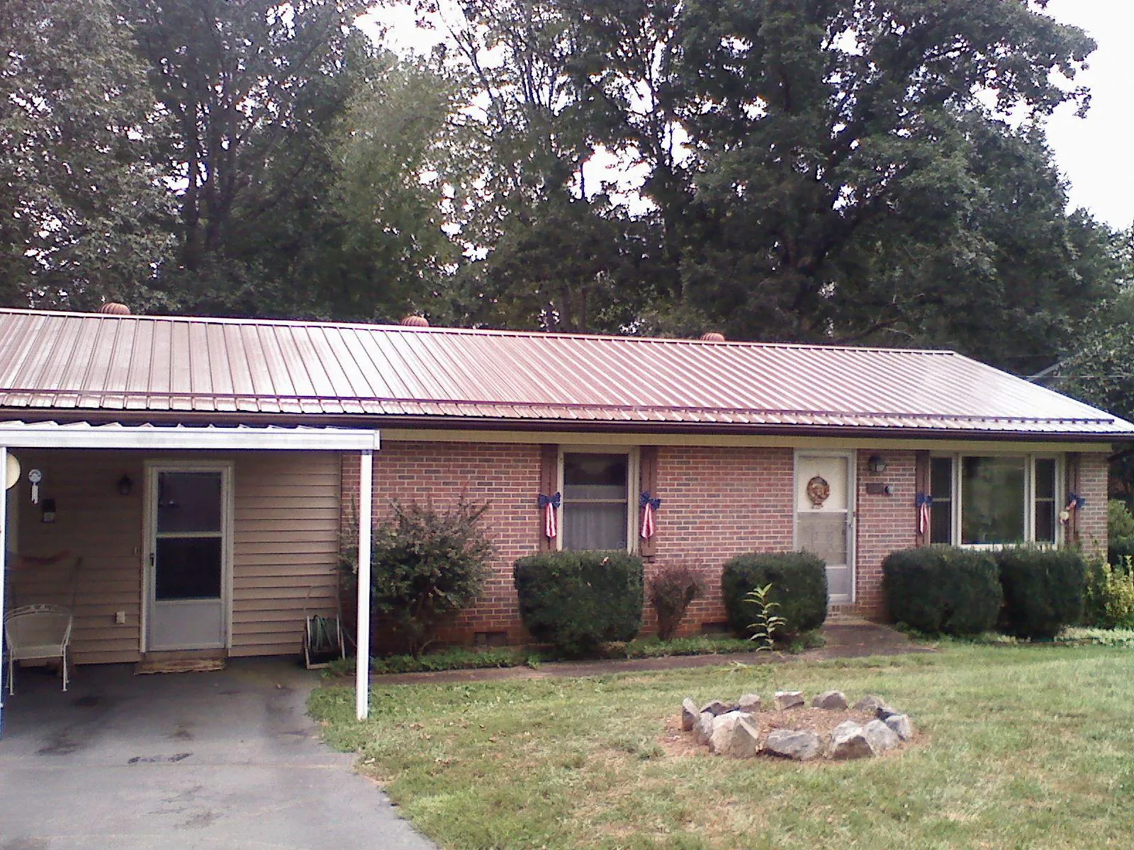Bronze metal roof and carport on a brick ranch home — Roof Repair work by our crew in Gerber